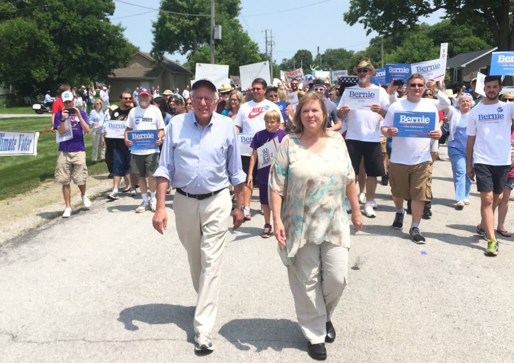 Sanders and wife Jane walk in the Waukee 4th of July parade