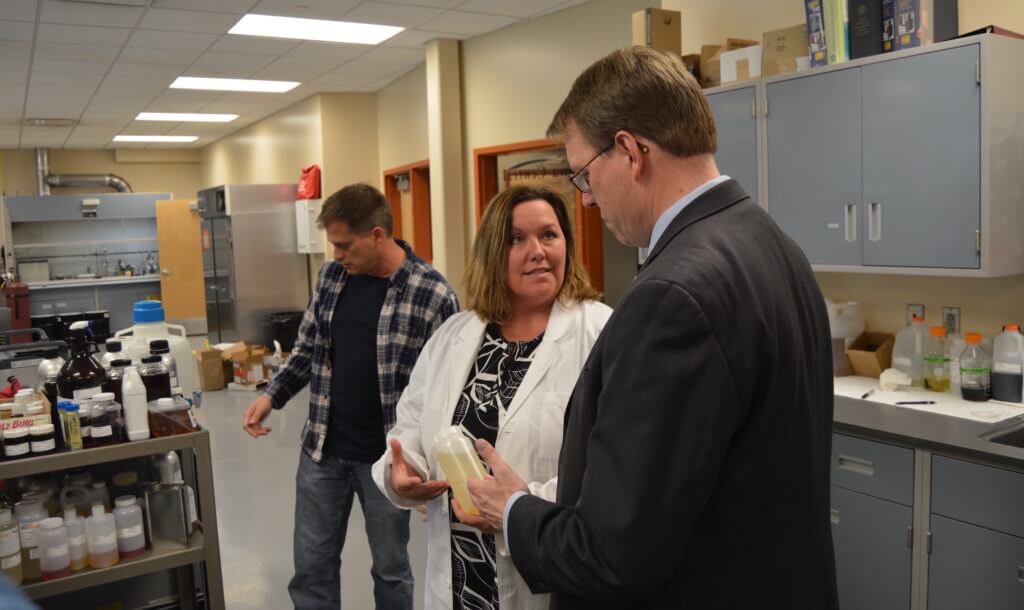 A lab worker shows Hogg a sample of ethanol they test