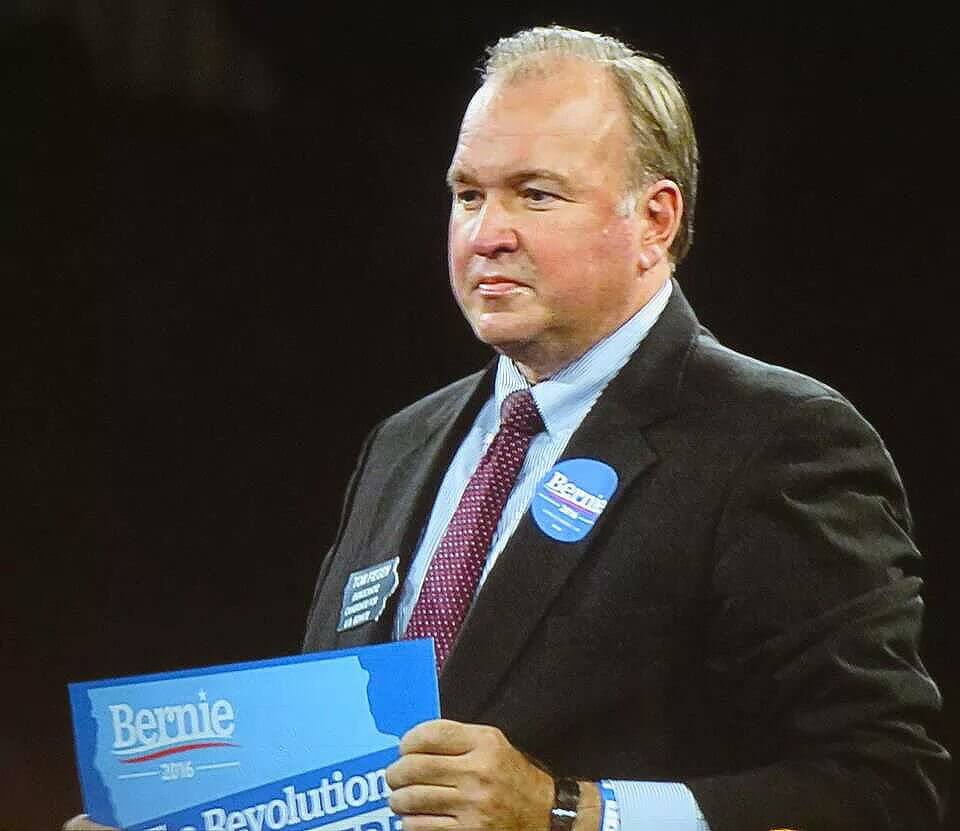 Fiegen hoists a Bernie sign at the Jefferson-Jackson Dinner to cheers