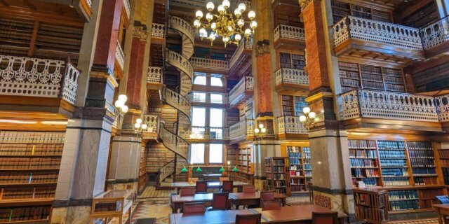 a photograph showing tables, spiral staircases and tall bookshelves